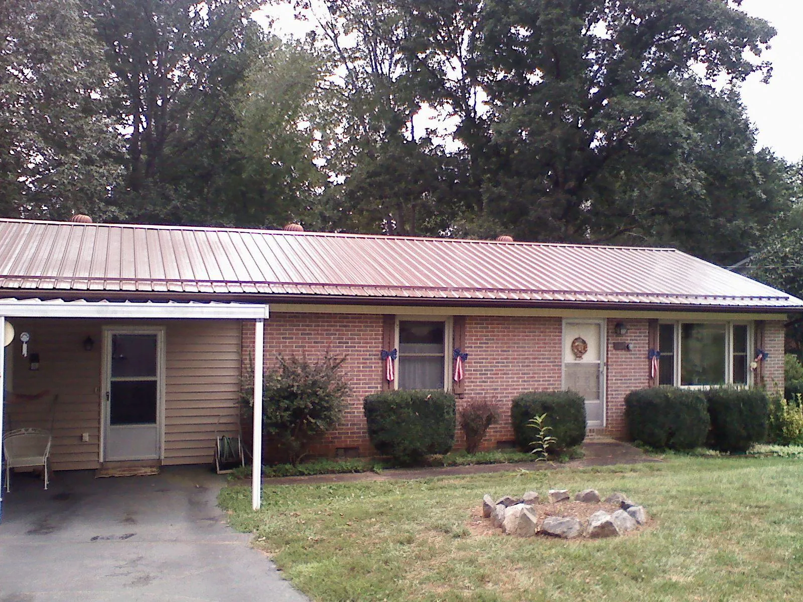 Bronze metal roof and carport on a brick ranch home — Roof Repair work by our crew in Clemson