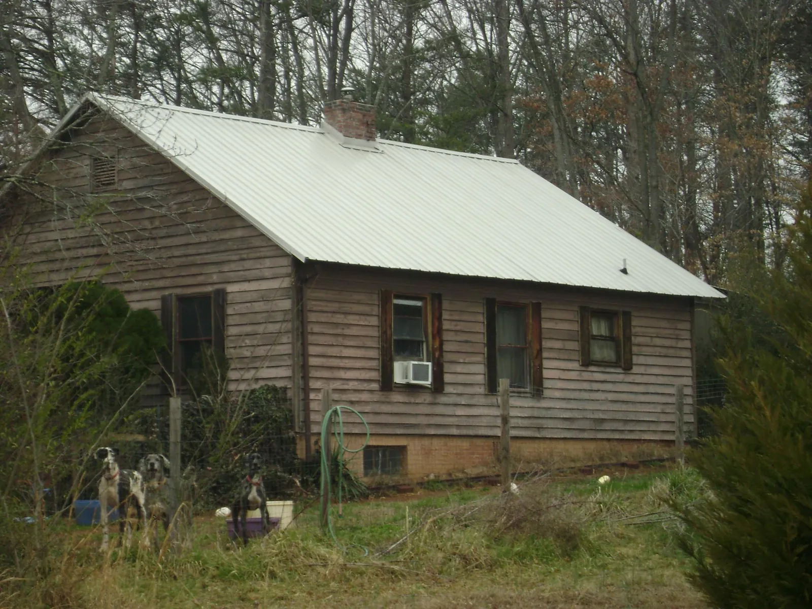White metal roof on an old wood sided farmhouse, from a Metal Roof Installation job in Clemson